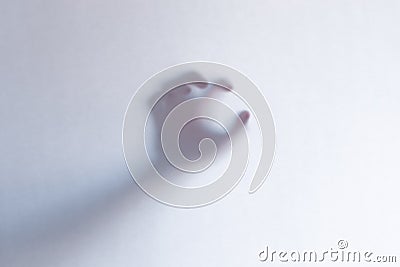 Defocused scary ghost hands behind a white glass background Stock Photo