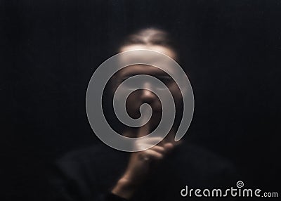 Blurred scary man silhouette behind a transparent plastic. Stock Photo