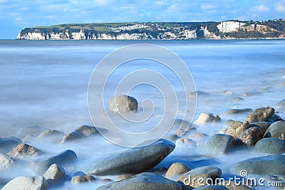 Blurred sea waves near town of Seaton Stock Photo