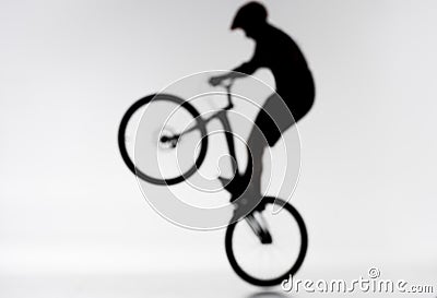 blurred shot of silhouette of trial biker performing bunny hop Stock Photo