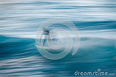 Blurred silhouette of a surfer on a wave. Concept of movement and speed Stock Photo