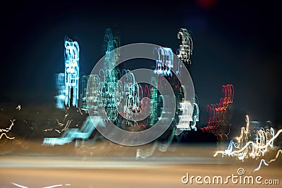 Blurred skyscrapers. Multistory buildings at night, Illuminated windows. Modern neon city at car speed, art background Stock Photo