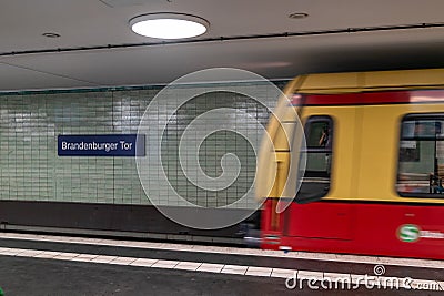 A blurred subway train enters the Brandenburg Gate station in Berlin Editorial Stock Photo