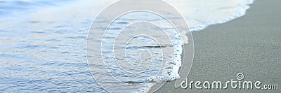 Blurred wave of the sea on the evening sand beach. banner. Editorial Stock Photo