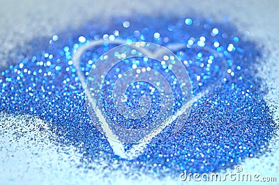 Blurry abstract background with heart of blue glitter sparkle on blue surface Stock Photo