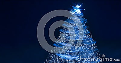 Blurry creative lighted christmas tree banner in monochrome classic blue palette on a dark background in trendy color of 2020. Stock Photo