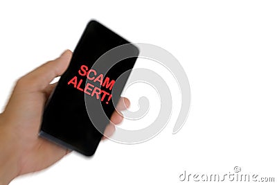 Blurry image of hand holding mobile phone with word SCAM ALERT Stock Photo