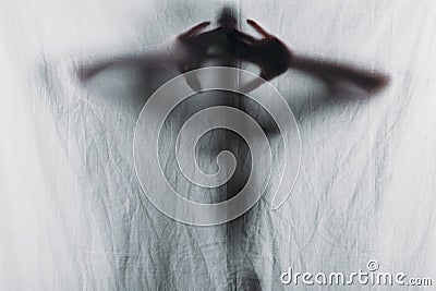 blurry silhouette of person touching curtain Stock Photo