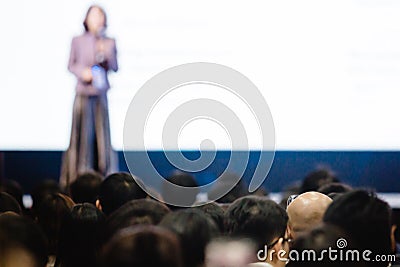 Blurry of woman speaker speech on stage in auditorium for shareholders` meeting Editorial Stock Photo