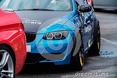 BMW M3 E90 Race Car wrapped in chrome blue vinyl wrap, equipped with angel eye headlights, custom wide body kit Editorial Stock Photo