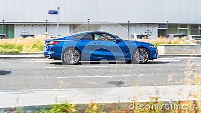 BMW 8 Series G15 car on the road in motion. Fast speed drive on city road. Side view of moving blue coupe BMW 840d on the street Editorial Stock Photo