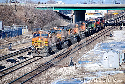 A BNSF diesel locomotive pulls multiple BNSF motive power in various historical color schemes showing years of mergers Editorial Stock Photo