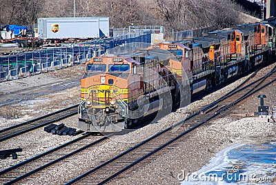 A BNSF diesel locomotive pulls multiple BNSF motive power in various historical color schemes showing years of mergers Editorial Stock Photo