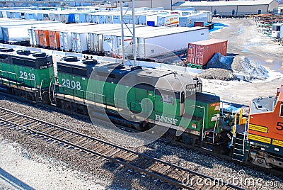 A BNSF diesel locomotive pulls multiple BNSF motive power in various historical color schemes showing years of mergers Editorial Stock Photo