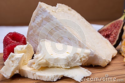 Board with french soft cheese Delice de Bourgogne French cow`s milk cheese from Burgundy region of France served with fresh Stock Photo