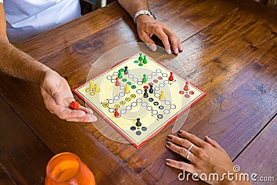 Board-game being played by a guy and a girl on a wooden table. Stock Photo