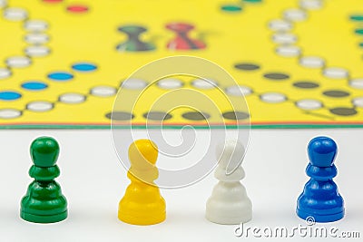 Board game with different colored game pawns on it. Ludo or Sorry board game play figures Stock Photo