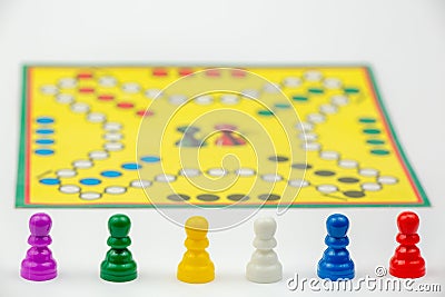 Board game with different colored game pawns on it. Ludo or Sorry board game play figures Stock Photo