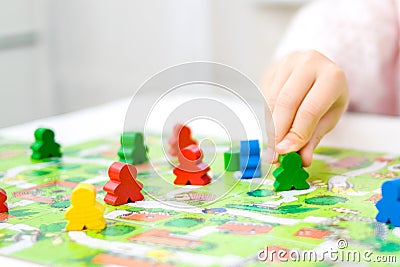 green people figure in hand of child. red, blue, green wood chips in children play - Board game and kids leisure concept Stock Photo