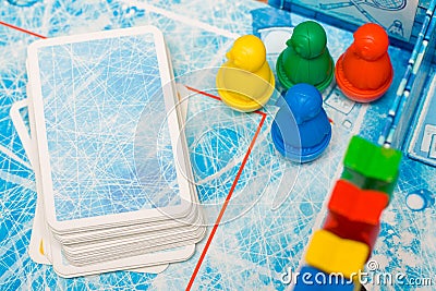 Board game and kids leisure concept - red, yellow, blue, green wood chips figure and playing cards in children play. Stock Photo