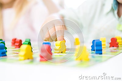 yellow people figure in hand of child. red, blue, green wood chips in children play - Board game and kids leisure concept Stock Photo