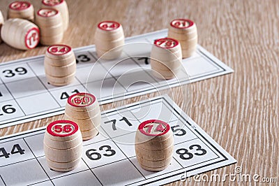 Board game lotto. Wooden lotto barrels and game cards for a game in lotto. Wooden background. Group entertainment, family leisure Stock Photo