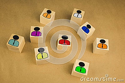 Board game pawn on top of wooden cube with other ones fallen against color background Stock Photo