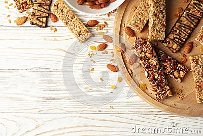 Board with granola bars and bowl almond on wooden background, top view Stock Photo