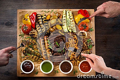 A board with grilled appetizers and sauces. Grilled vegetables and meat snack Stock Photo