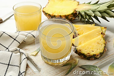 Board with pineapple and glasses with juice Stock Photo