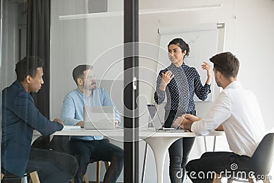 Multi-ethic business people listens indian woman coach giving presentation Stock Photo