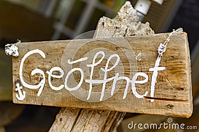 Board on a wooden post in front of a shop Stock Photo