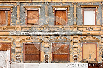 Boarded up derelict building facade peeling paint Stock Photo