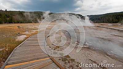 Boardwalk curving around Hot Cascades hot spring in the Lower Geyser Basin in Yellowstone National Park in Wyoming Stock Photo