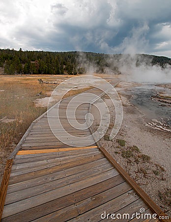 Boardwalk curving around Hot Cascades hot spring in the Lower Geyser Basin in Yellowstone National Park in Wyoming Stock Photo