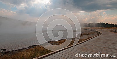 Boardwalk curving around Hot Lake hot spring in the Lower Geyser Basin in Yellowstone National Park in Wyoming USA Stock Photo
