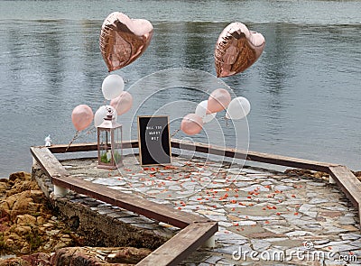 Boardwalk proposal with Gold balloons Stock Photo