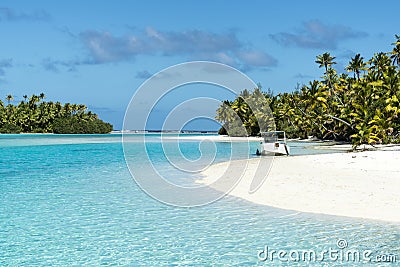 Boat anchoring on small island in turquoise clear water, deep blue sky, white sand, Pacific Island Stock Photo