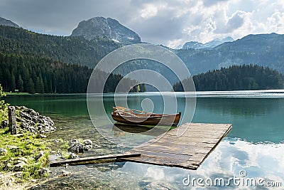 Boat on Black Lake in the national park Durmitor and mountains i Stock Photo
