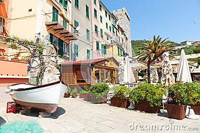 Boat on blocks on cobbles by cafe and colourful Ligurian homes Editorial Stock Photo