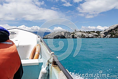 A boat crosses a turquoise color lake. Lago General Carrera, Chile Stock Photo