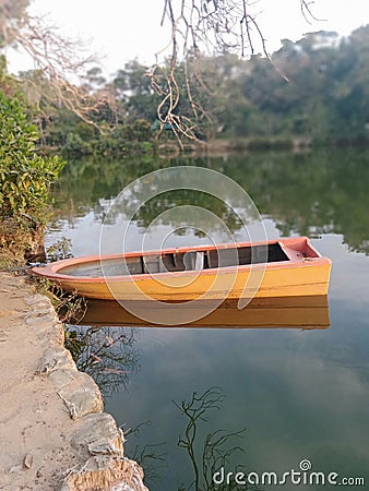 a boat that is on the edge of the lake very yellow Stock Photo