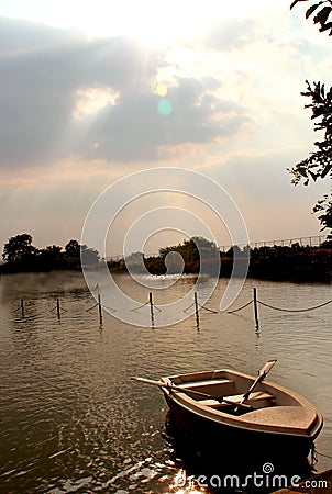 A boat in the lake with sunset sky at sittanavasal cave temple complex. Stock Photo