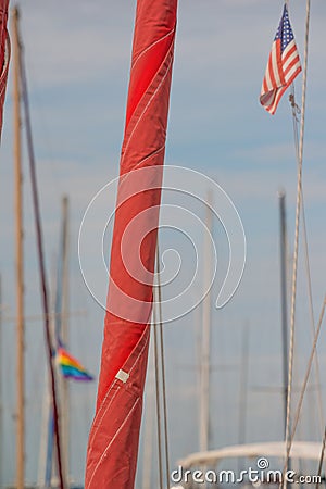 Boat masts in Fisherman`s Wharf area of San Francisco with the American flag and gay pride flag flowing in the wind Stock Photo