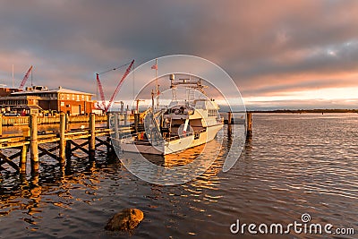 Boat moored to a jetty at sunset Stock Photo