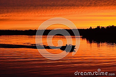 Boat Motoring After Sunset Stock Photo