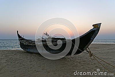 Boat on the ocean shore at sunset. Kerala, India Stock Photo