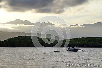 Boat with outriggers in a bay Stock Photo