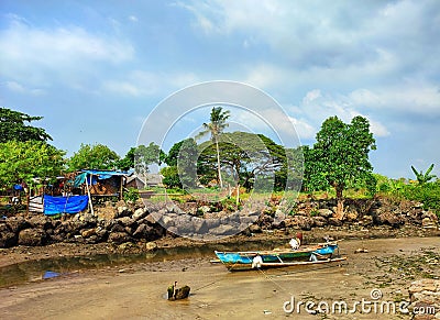 a boat parked at the mouth of a dry river. beautiful sky and small house near the river Stock Photo