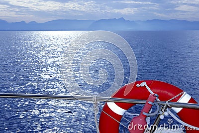 Boat rail with round orange lifesaver blue sea Stock Photo